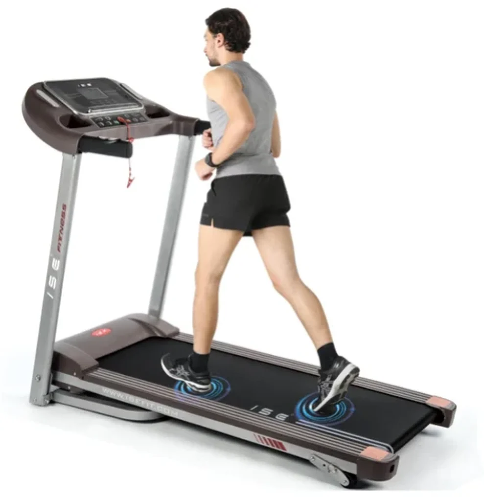 Homme en train de courir sur le tapis de course ISE SY-T2708, modèle pliable avec écran LCD, poignées équipées de capteurs de fréquence cardiaque et surface de course amortissante.